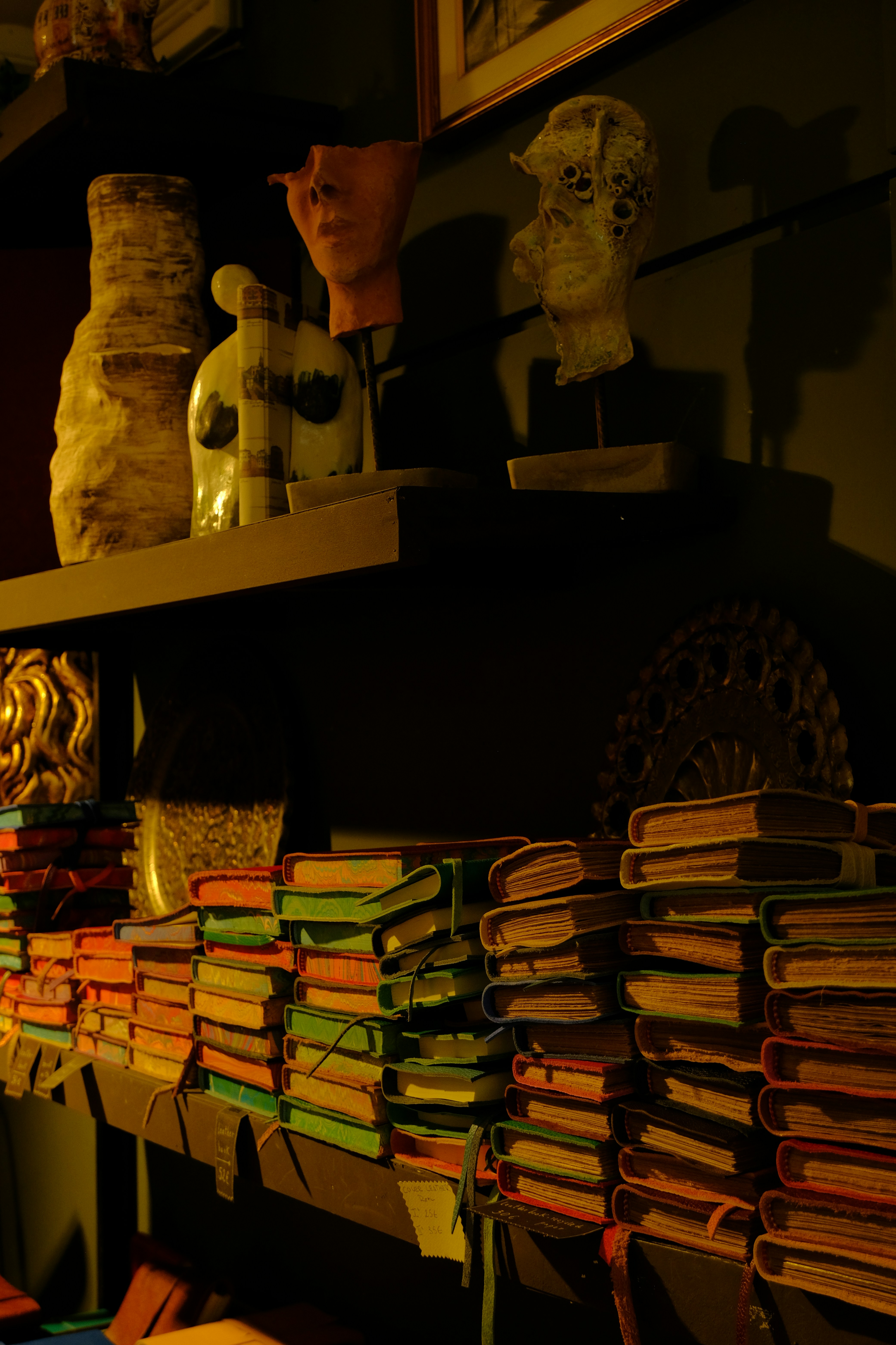 A shelf filled with lots of books and vases photo Free Fujifilm Image on Unsplash