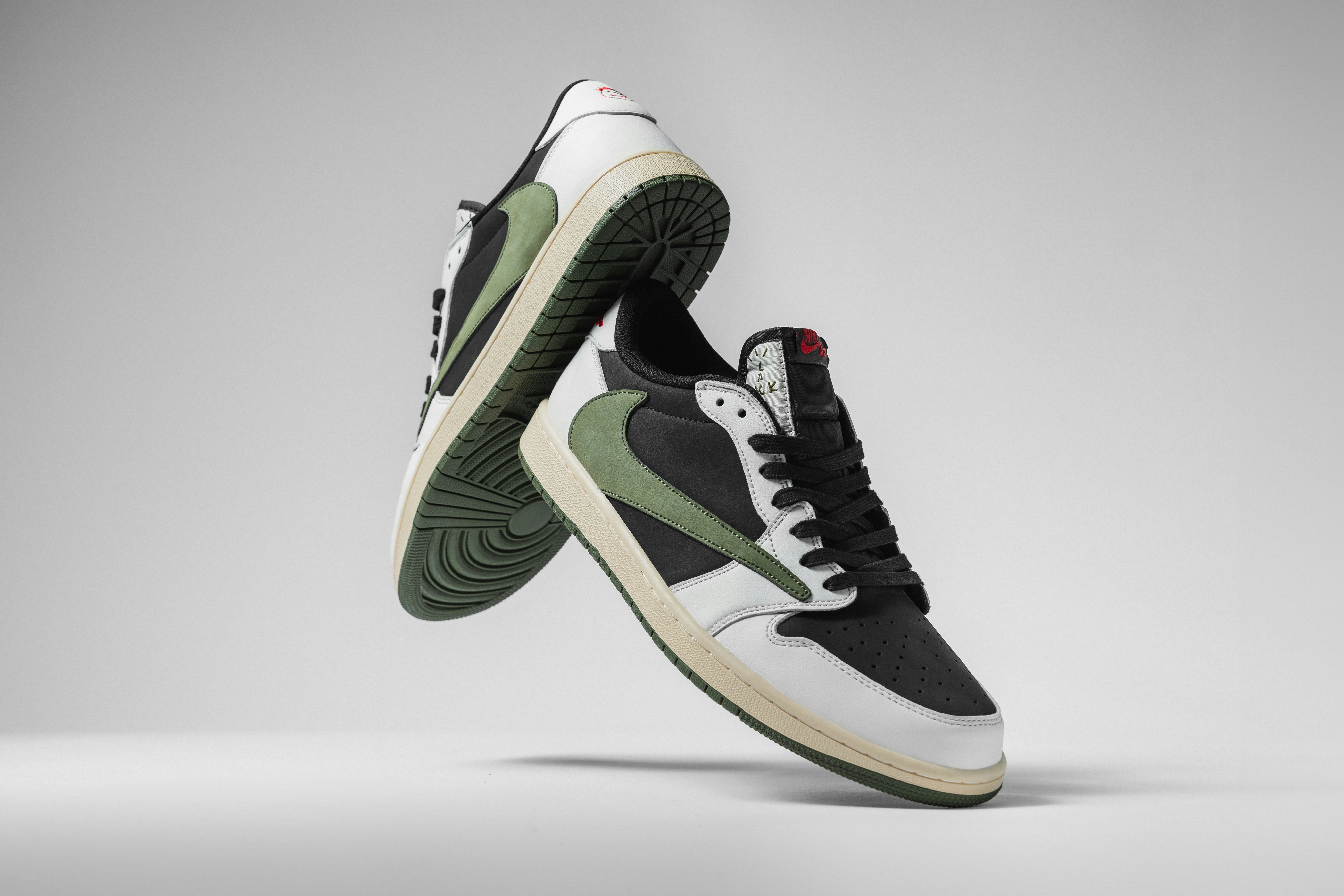 A pair of black and white sneakers with green accents photo Free