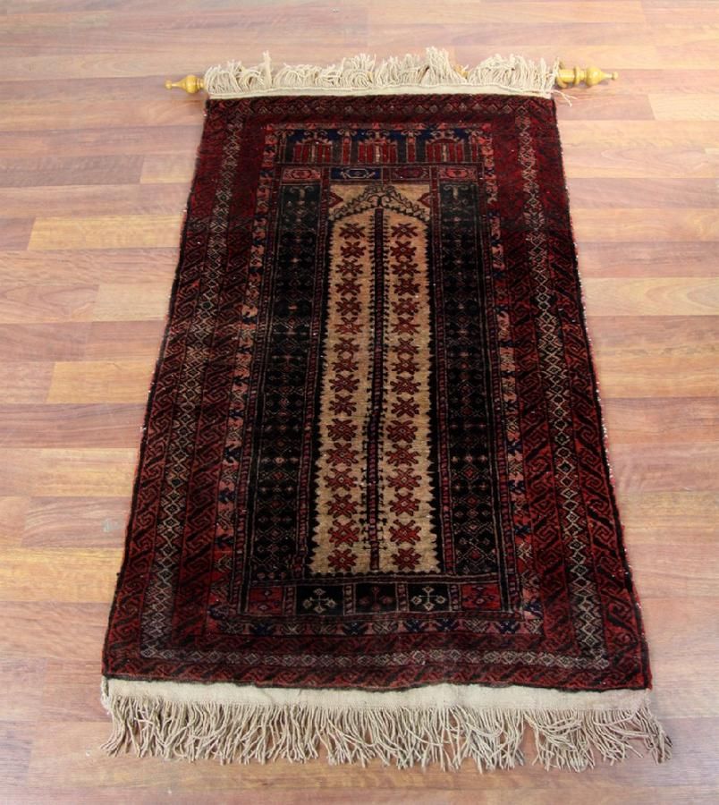 An Afghan Baluchi woollen tribal rug. The centre with a beige… Rugs