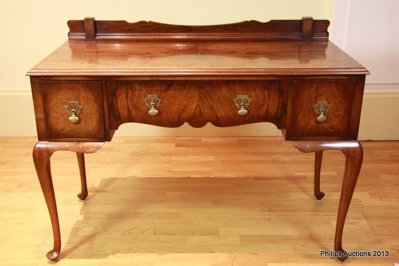 An English mahogany Queen Anne style desk, with a low shaped… Desks
