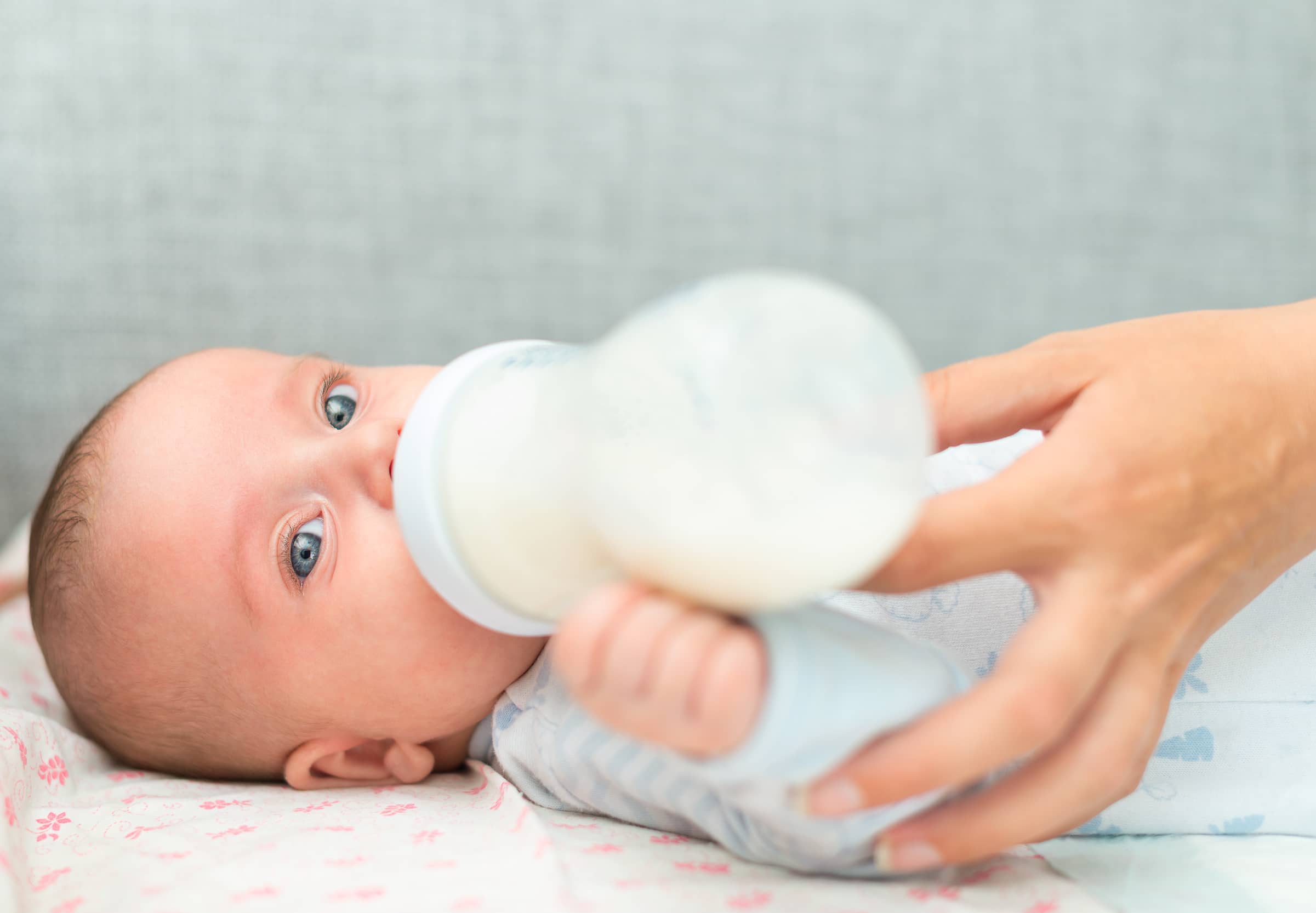 Mother feeding newborn baby from the bottle. Infant Nutrition Council