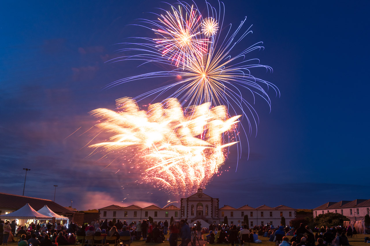 Fireworks light up the sky above Fort Mitchel on Spike Island. a crowd watches, surrounded by the buildings of the fort