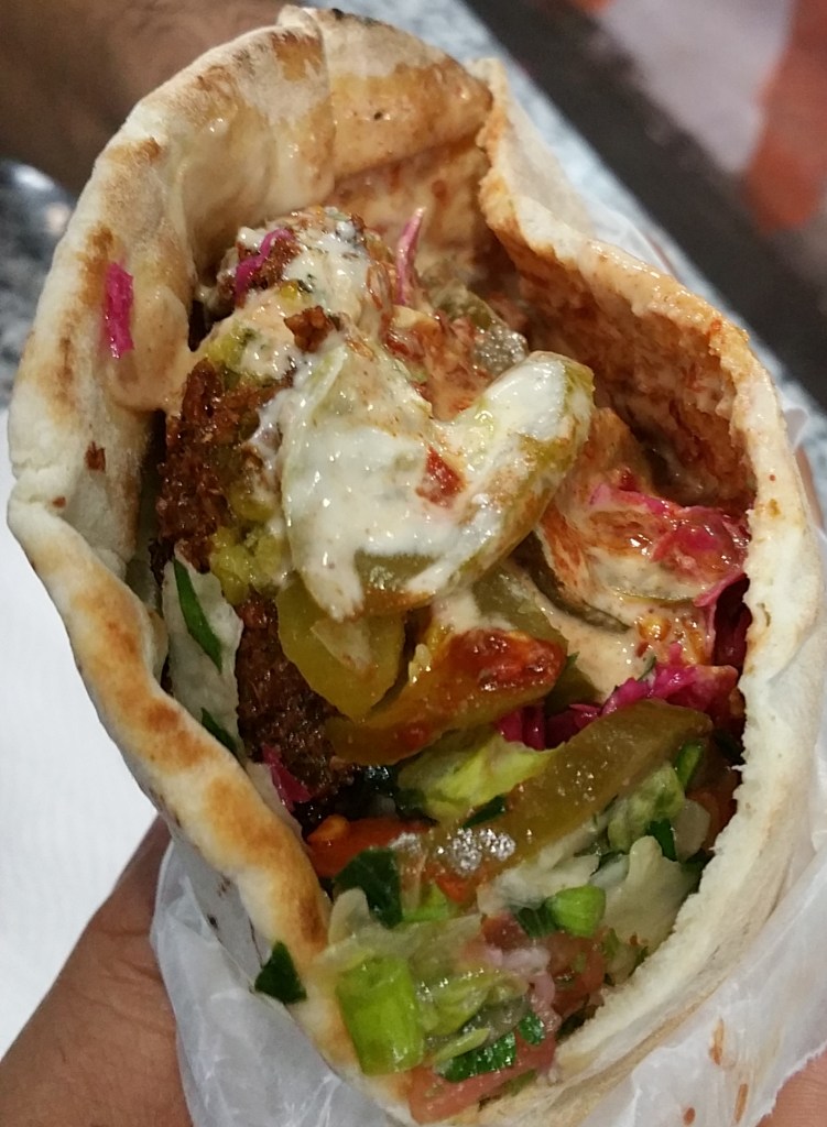 Falafel pita wrap loaded with sauces and veggies from Oasis in Brooklyn