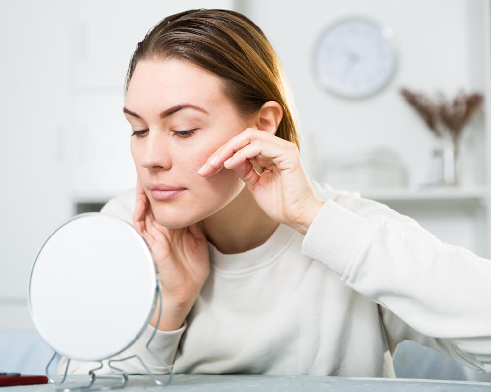 Woman touching winter skin problems on face