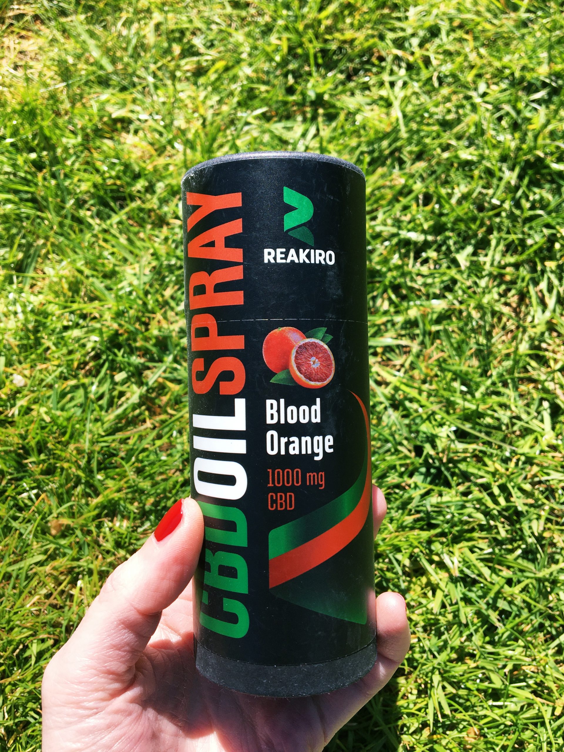 Me holding the oil spray. It's black and cylindrical, looking like a can of pop, with green, white and red designs for the text.