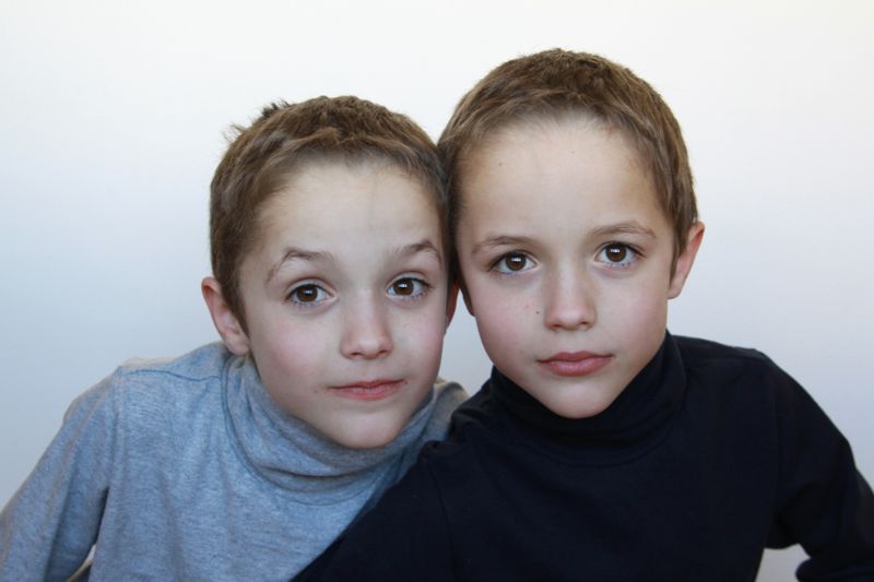 two young boys looking at the camera with white background
