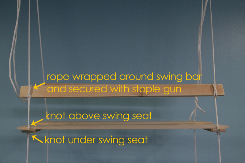 Stuffed animal swing: Rope wrapped around swing bar and secured with staple gun; knot above swing seat and knot under swing seat
