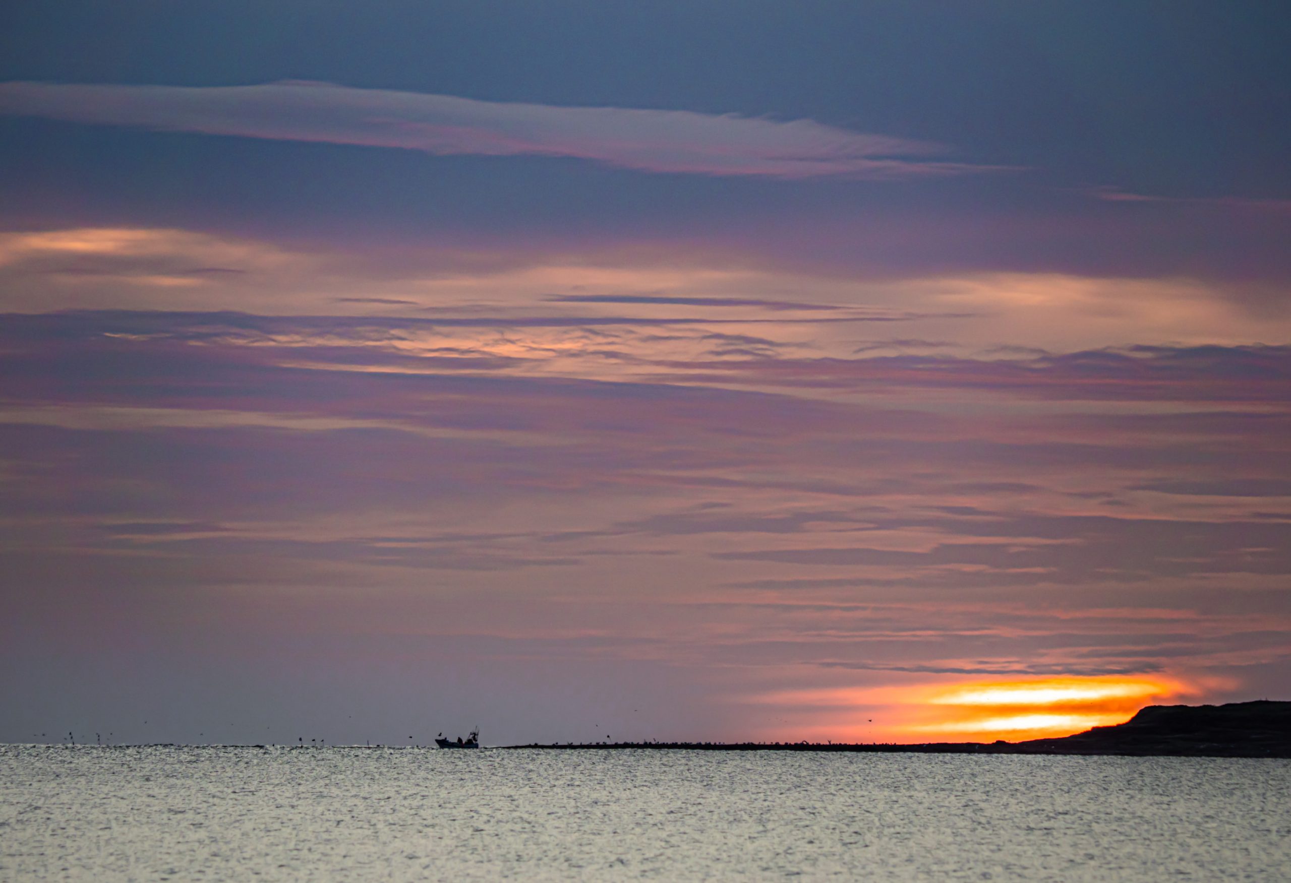 Fishing boat at sunrise. Mental health can be boosted by taking photographs.