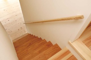 2026nagano_kita-ken11 階段を上がると左右に分かれて部屋があるレイアウト。片方には夫婦の寝室、もう片方にはご主人の仕事部屋がある。隣接する建物が視界に入らないように窓は最小限に抑えられているが、全く窮屈さを感じさせることなく、心地よい拡がりのある空間に仕上がっている