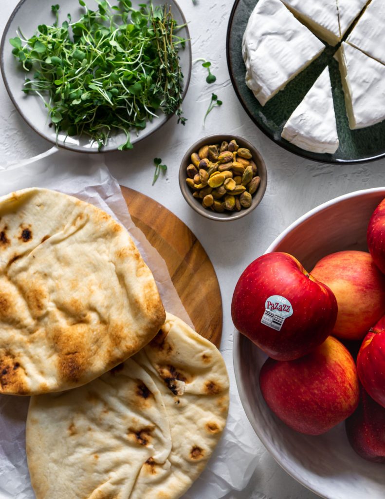 ingredients for baked brie flatbread pizza, apples, naan, pistachios