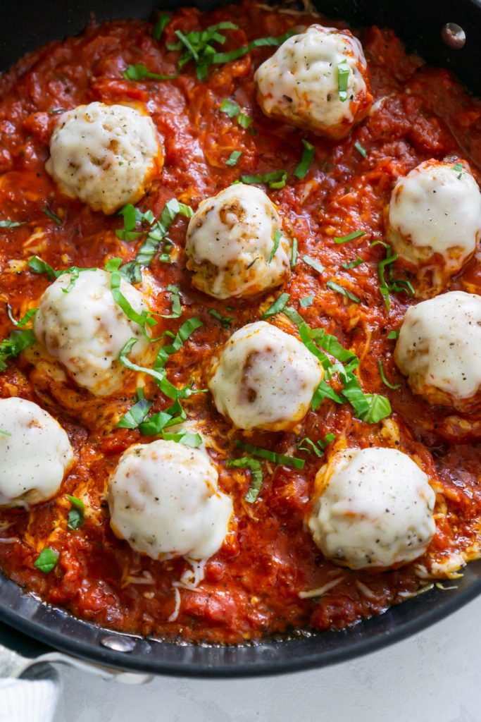 parmesan chicken meatballs in a pan with marinara sauce