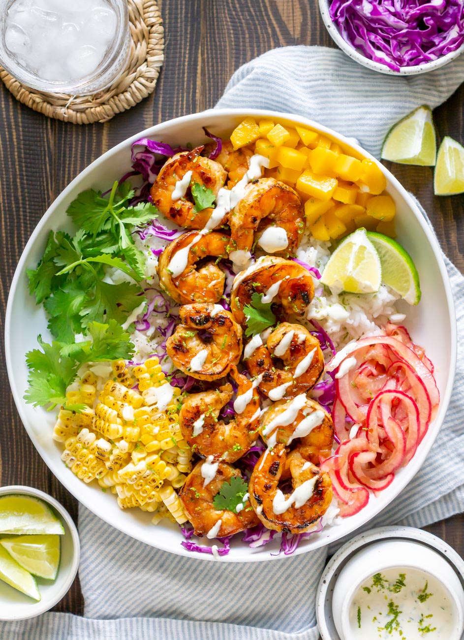 Shrimp Taco Bowl with crema drizzled over the top in a white bowl.