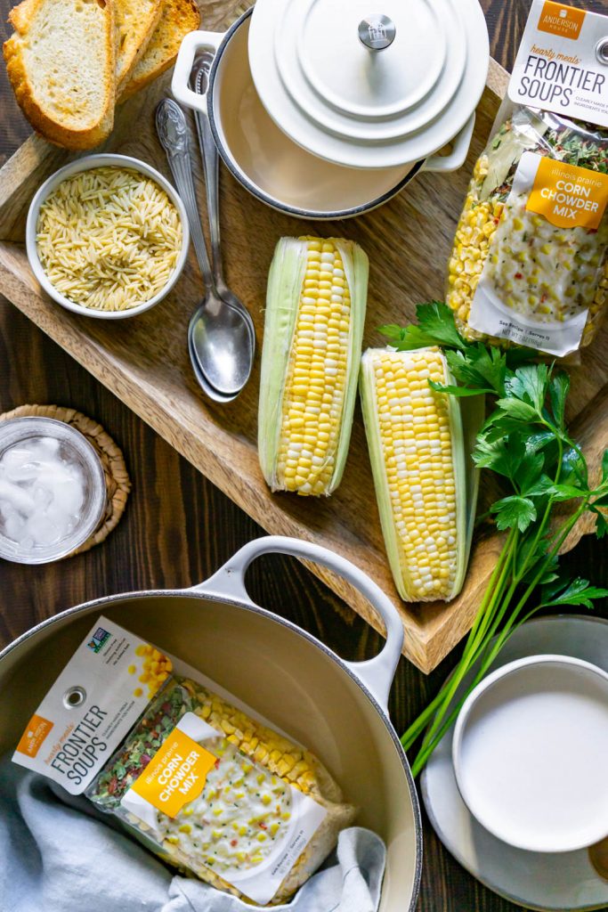 corn, wood tray, large pot, and toasted bread.