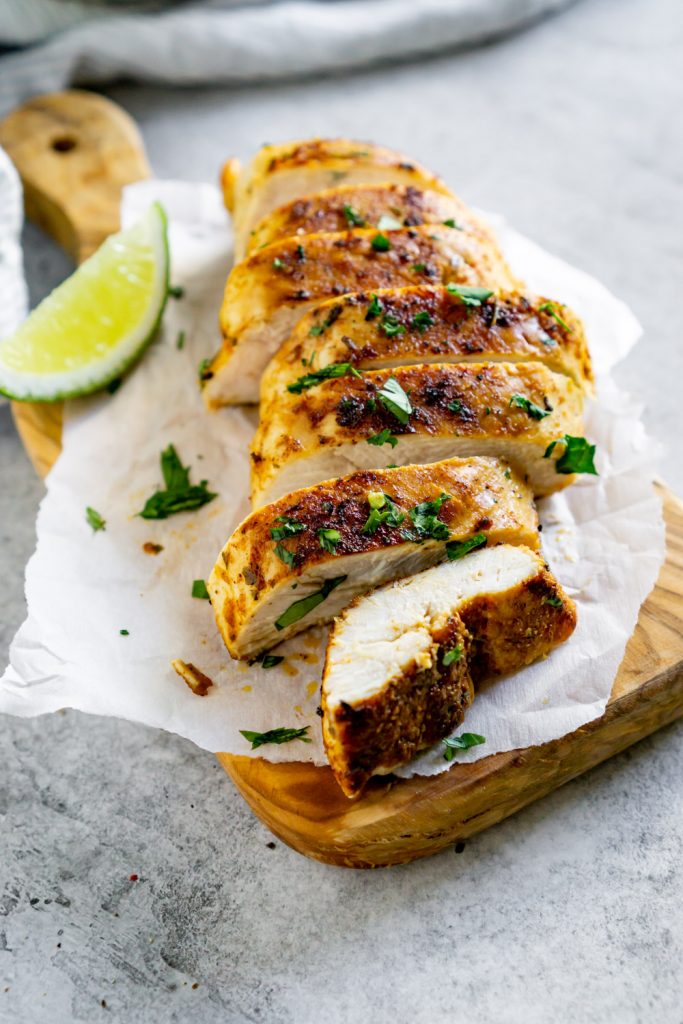 sliced chicken on a wood serving board