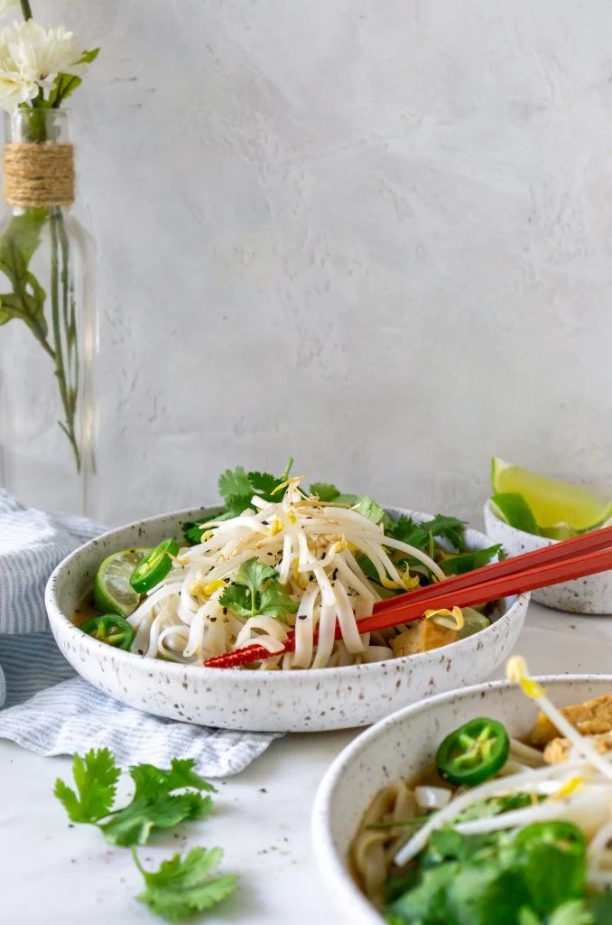 two bowls of chicken pho with chopsticks