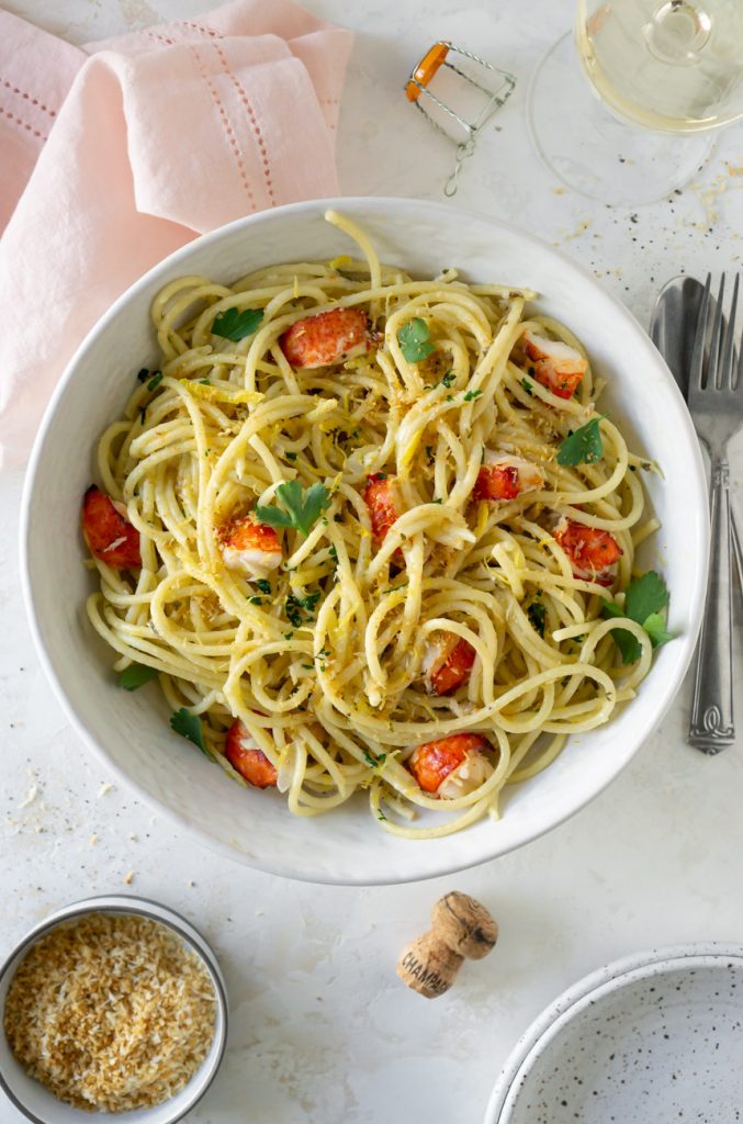 lobster pasta in a large white bowl with a pink napkin