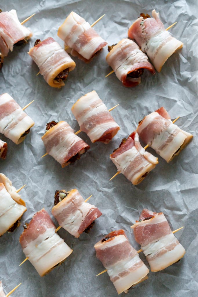 dates wrapped in bacon on parchment paper