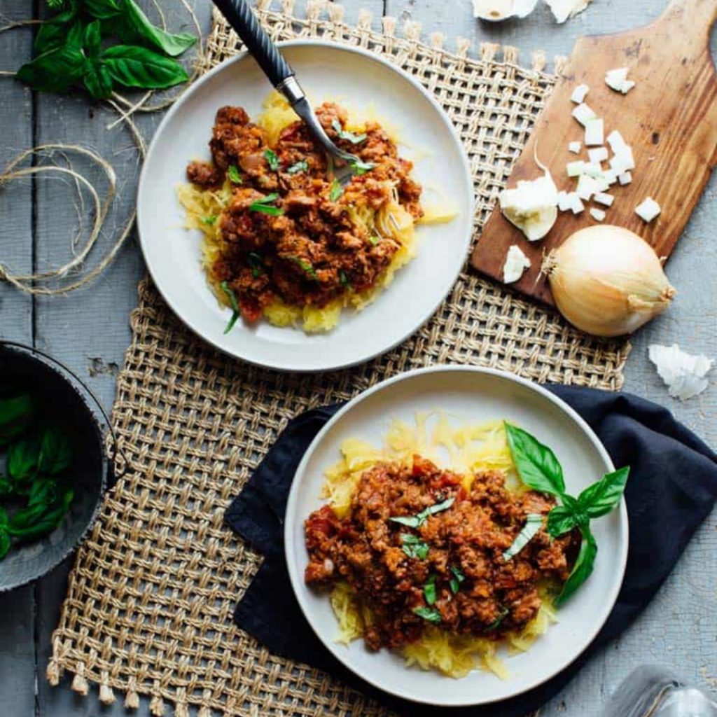 turkey sausage ragu over spaghetti squash on a white plate