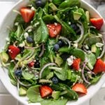 Strawberry spinach salad in a large white bowl.