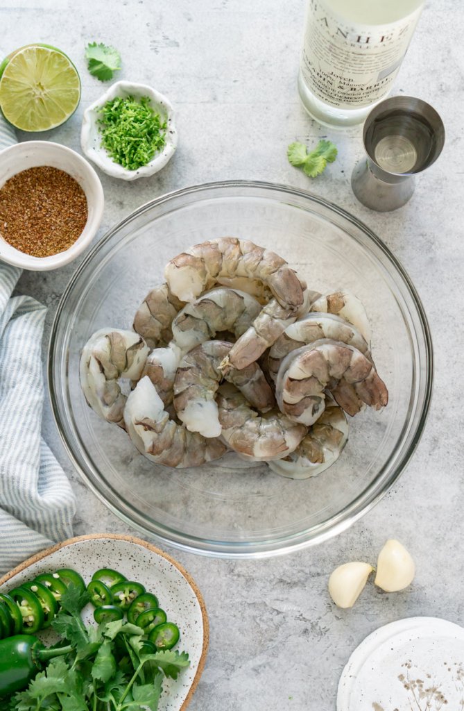 ingredients in bowls: shrimp, jalape&ntilde;o, mezcal, lime, cilantro, garlic