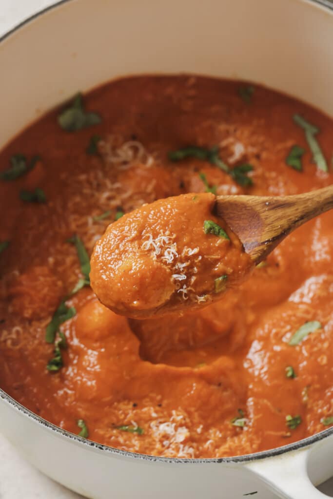 roasted vegetable soup in a pot with a wooden spoon