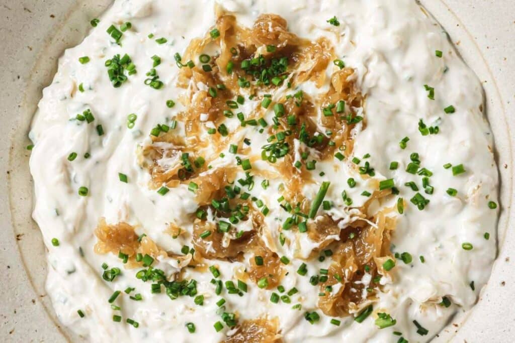 An up close look at french onion dip in a bowl after being chilled in the fridge.