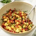 A bowl of peach salsa with a spoon resting on the side.