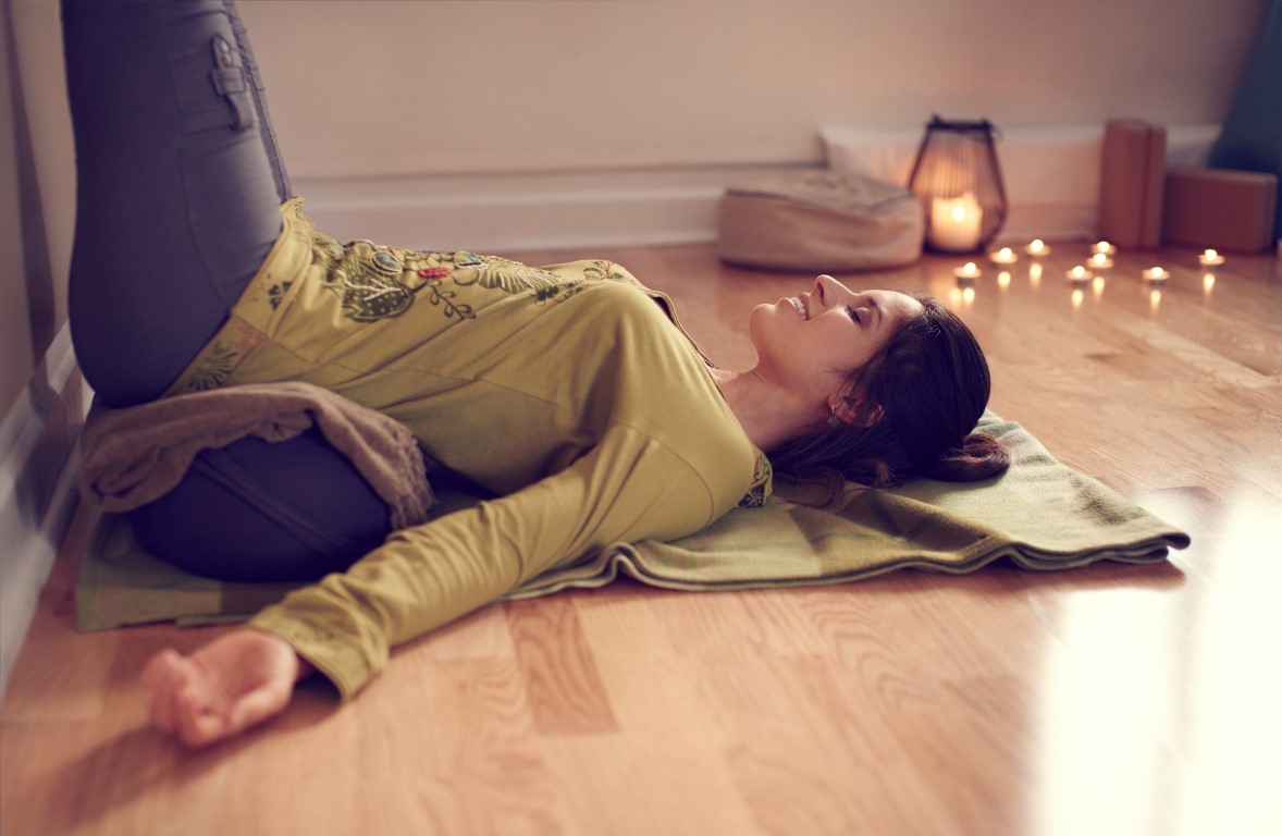 Attractive mixed race woman doing restorative yoga Kath Turner Yoga