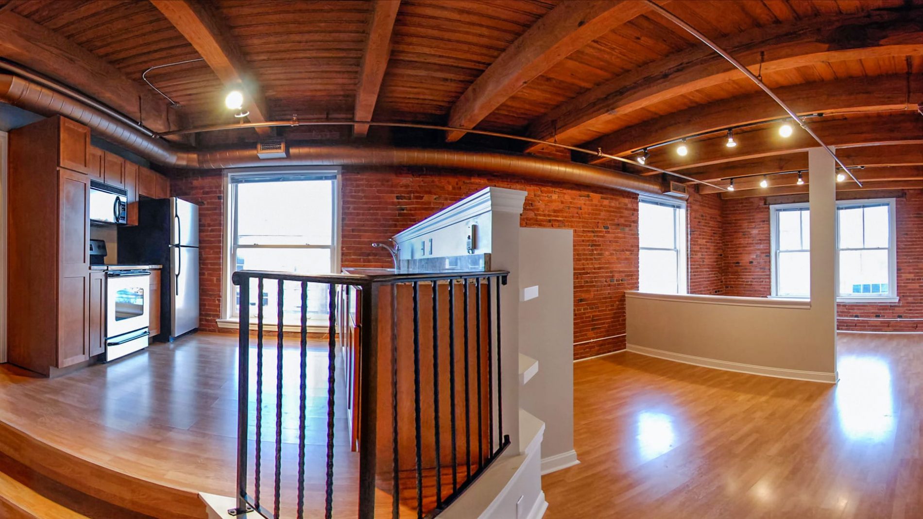 Studio Lofts With Wood Beams, Brick Walls, & Urban Views