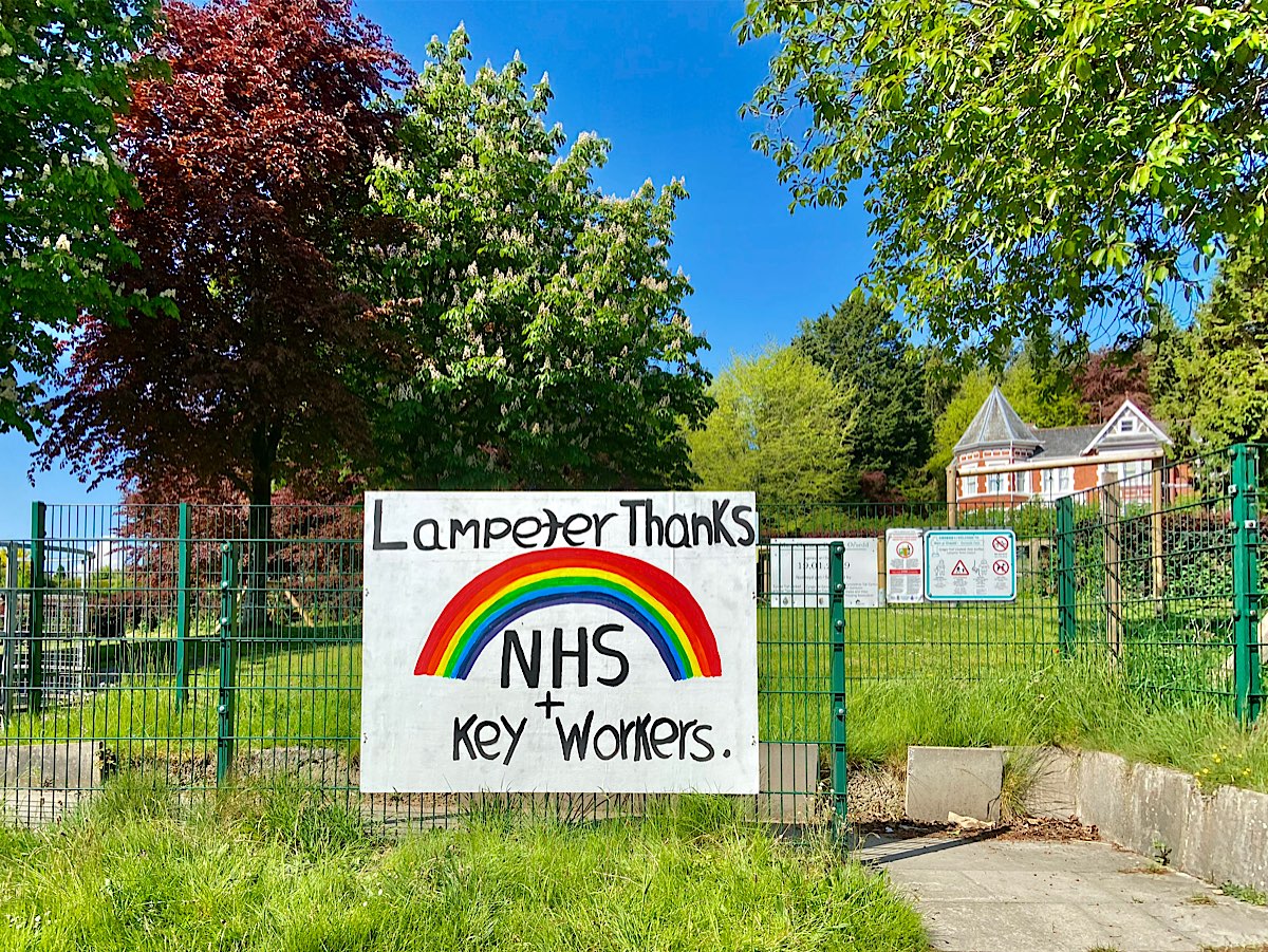 This is a great banner image with the words Lampeter Thanks above the rainbow, then NHS + Key Workers below it. It is shown here in situ with the park and trees behind it.