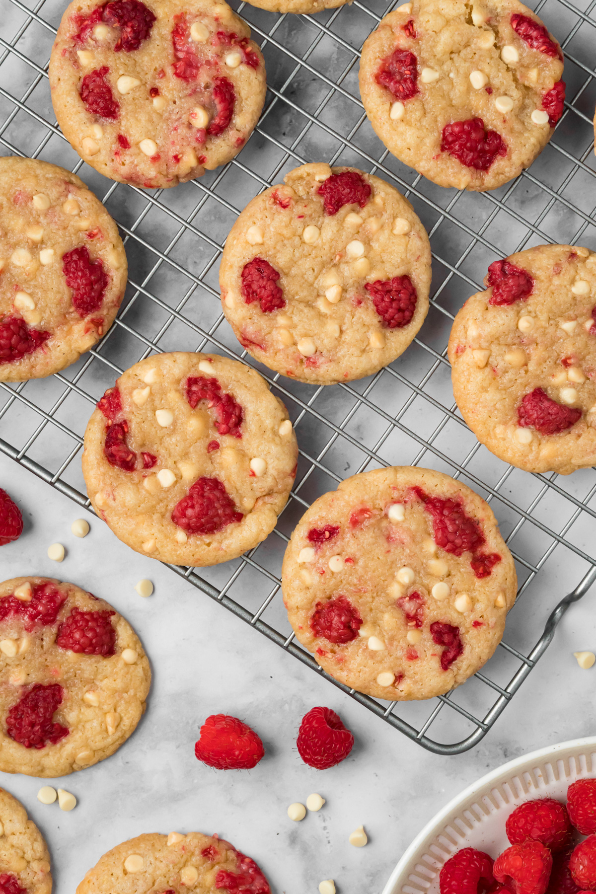 Raspberry white chocolate cookies on a wire rack.