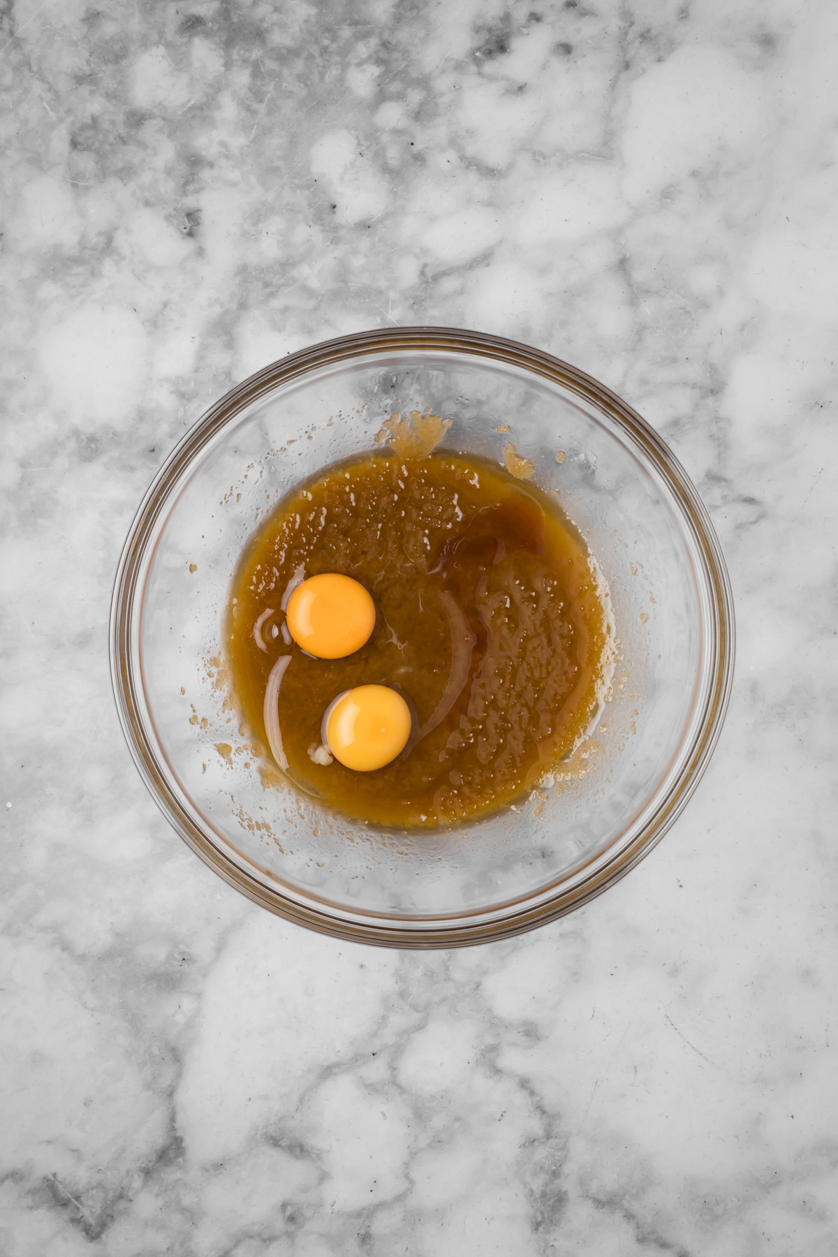 Egg and egg yolk added into the glass bowl.
