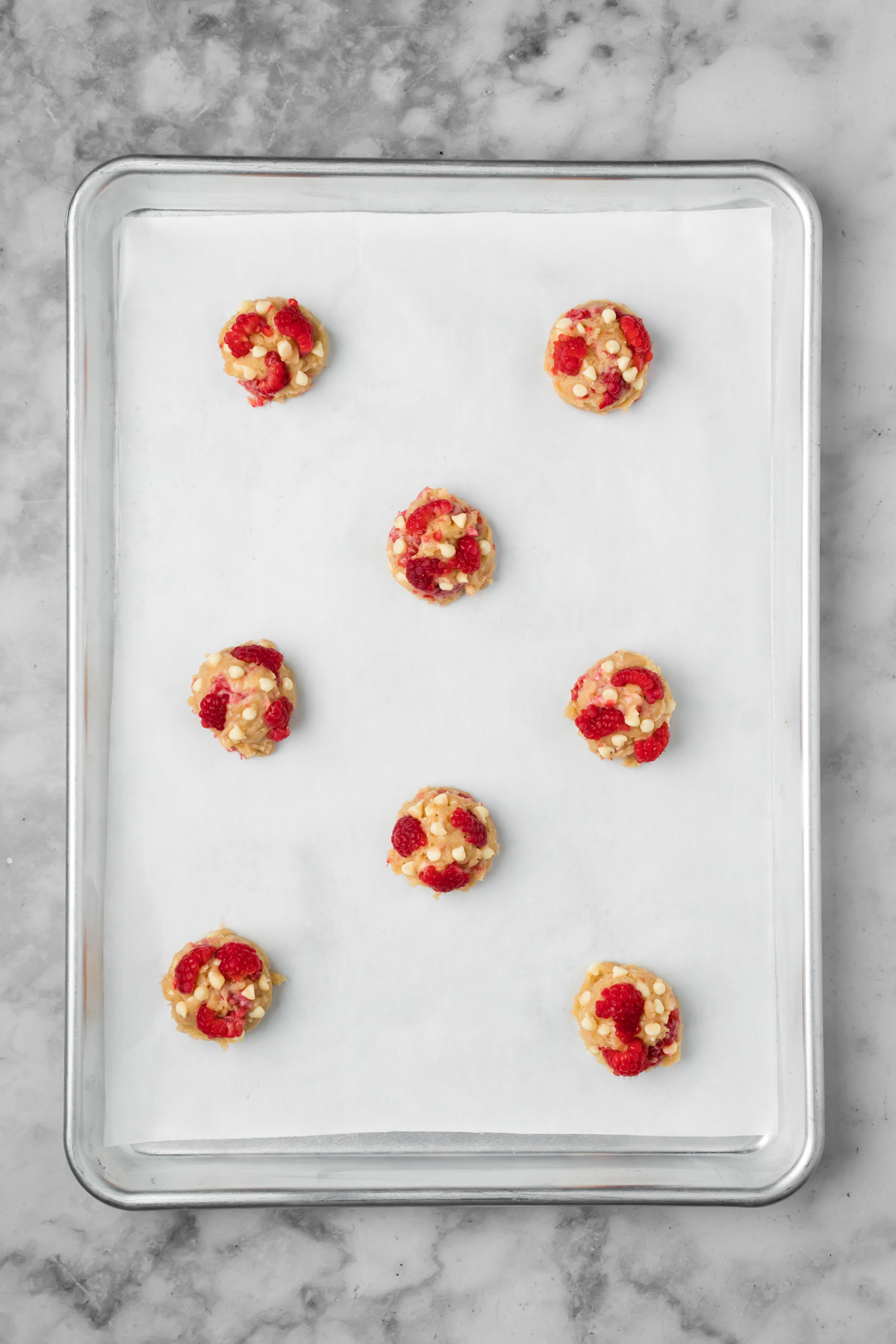 Cookie dough balls on a baking sheet.