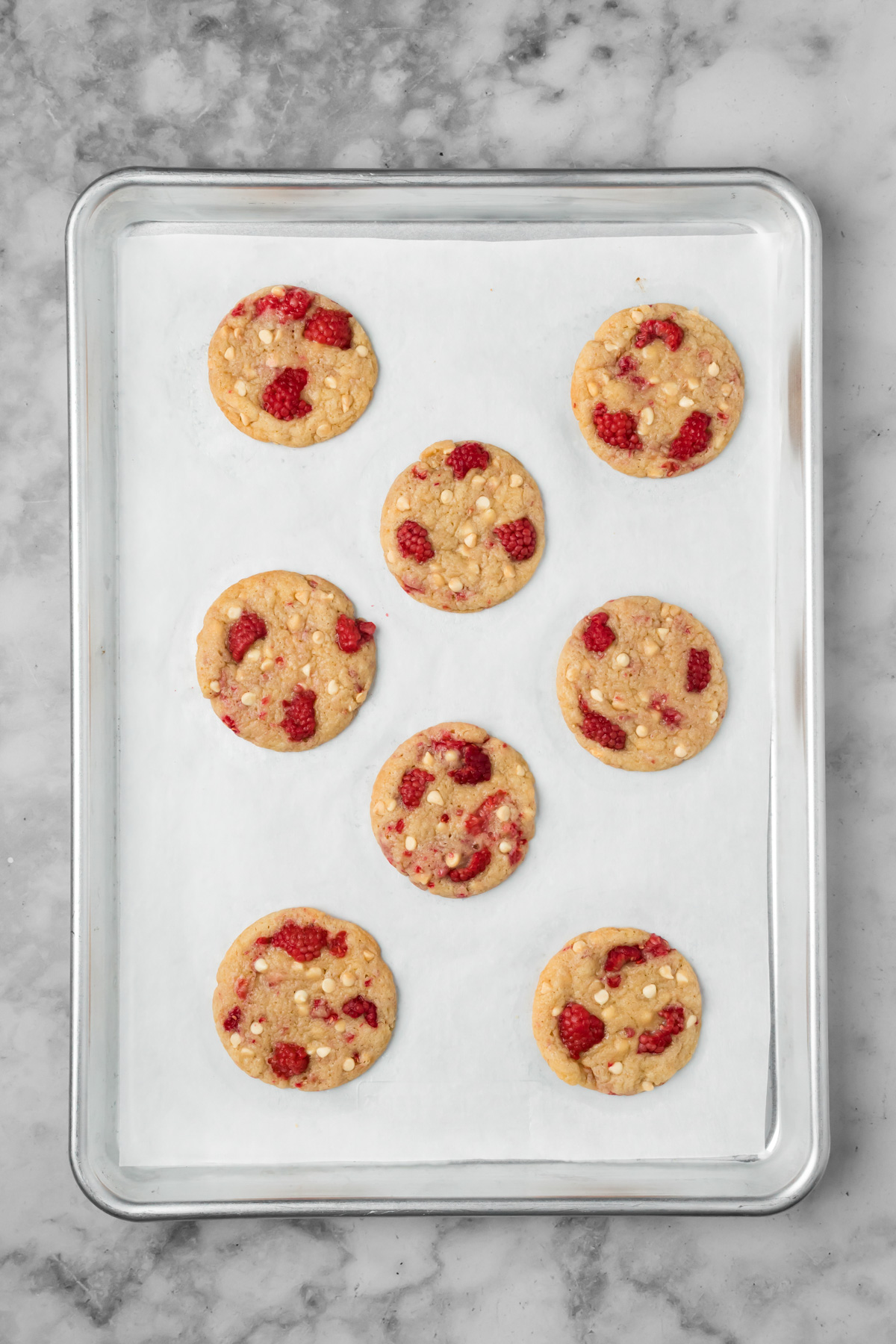 White chocolate raspberry cookies on a baking sheet after baking.