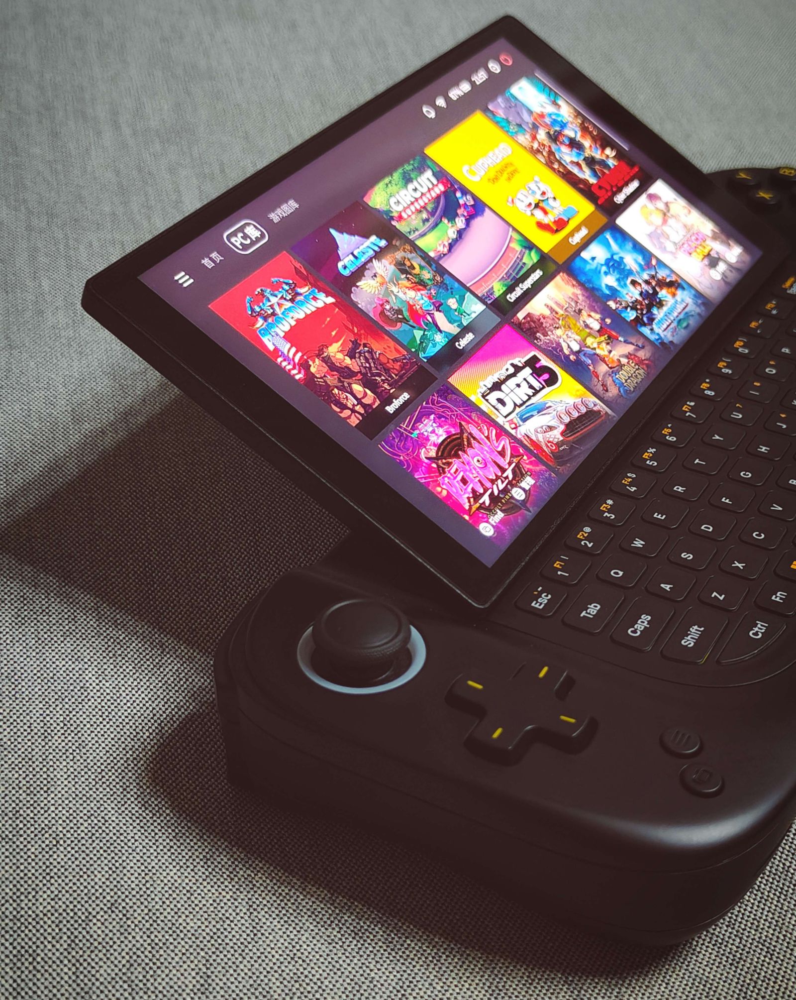 AYA Neo Flip handheld gaming PC with clamshell design and thumb