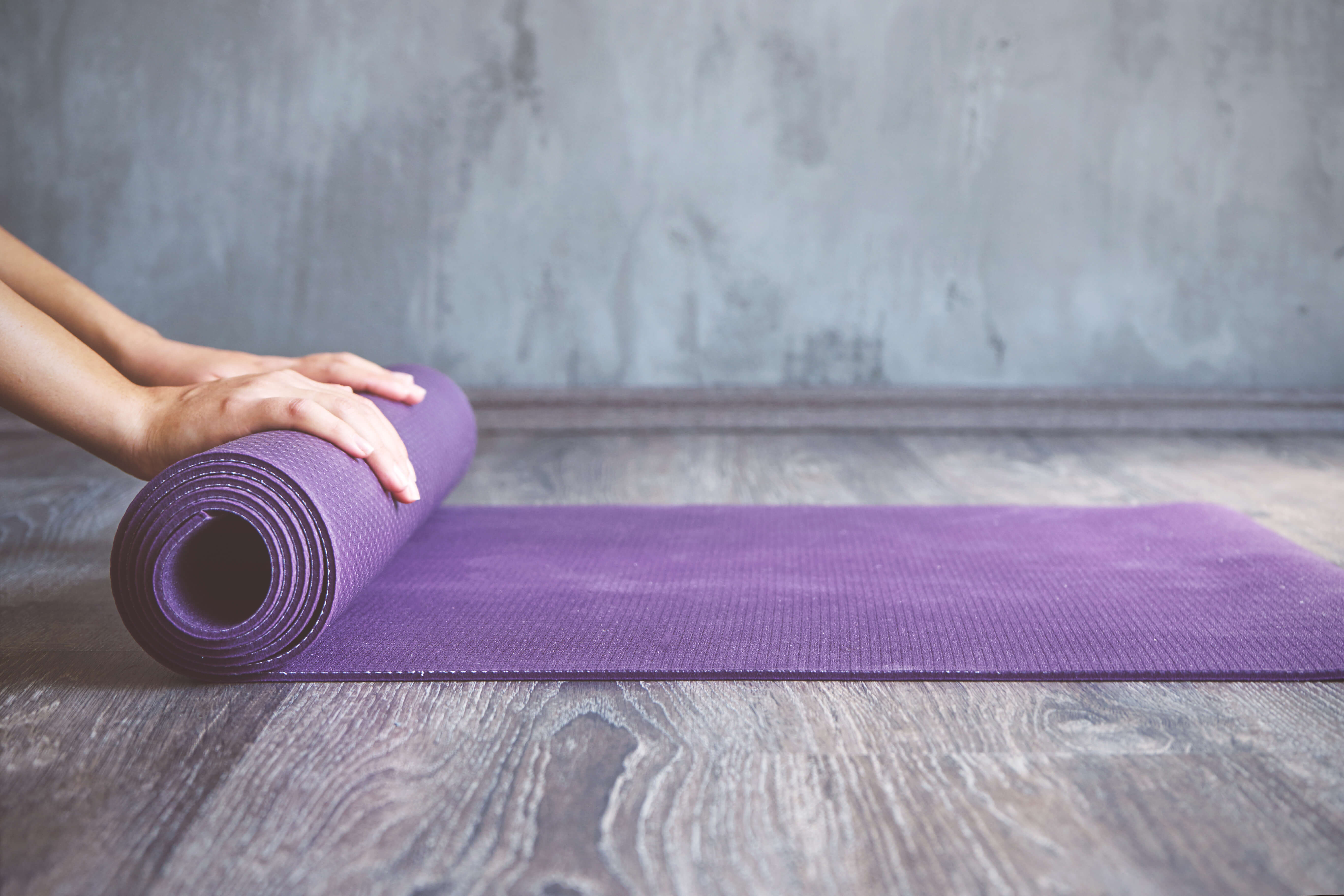 Woman rolling her mat after a yoga class Lindsey Elmore