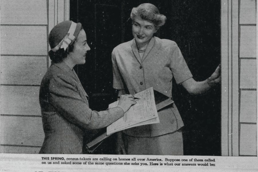 Black and white photo of female census taker in hat gathering information from woman at the door