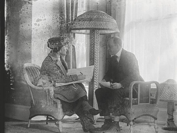Black and white photo of woman taking census information from man ~1920