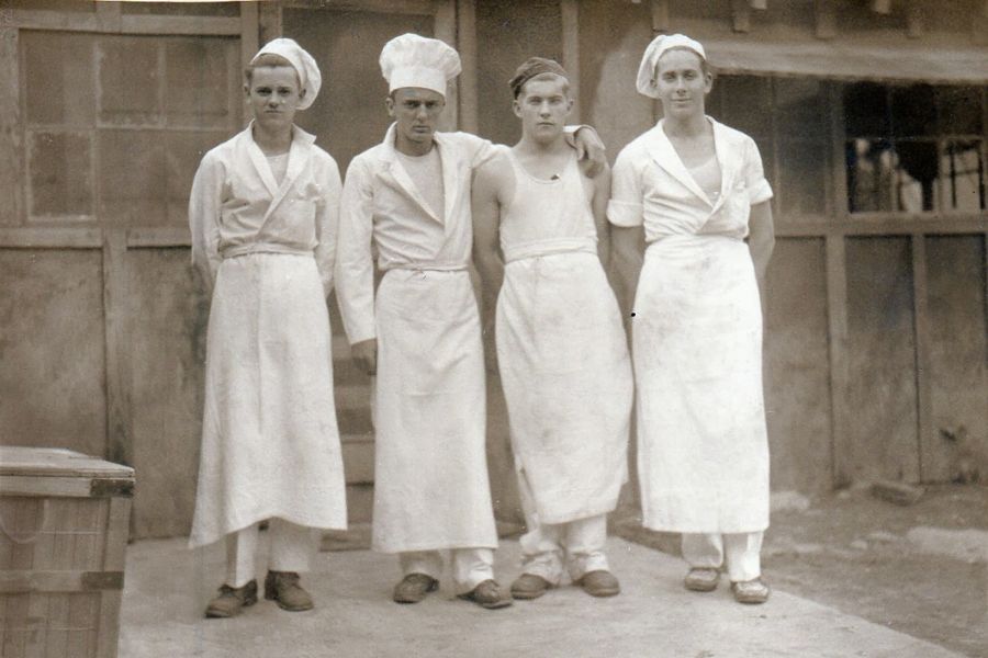 Black and white photos of Four young men dressed in cooks clothes.