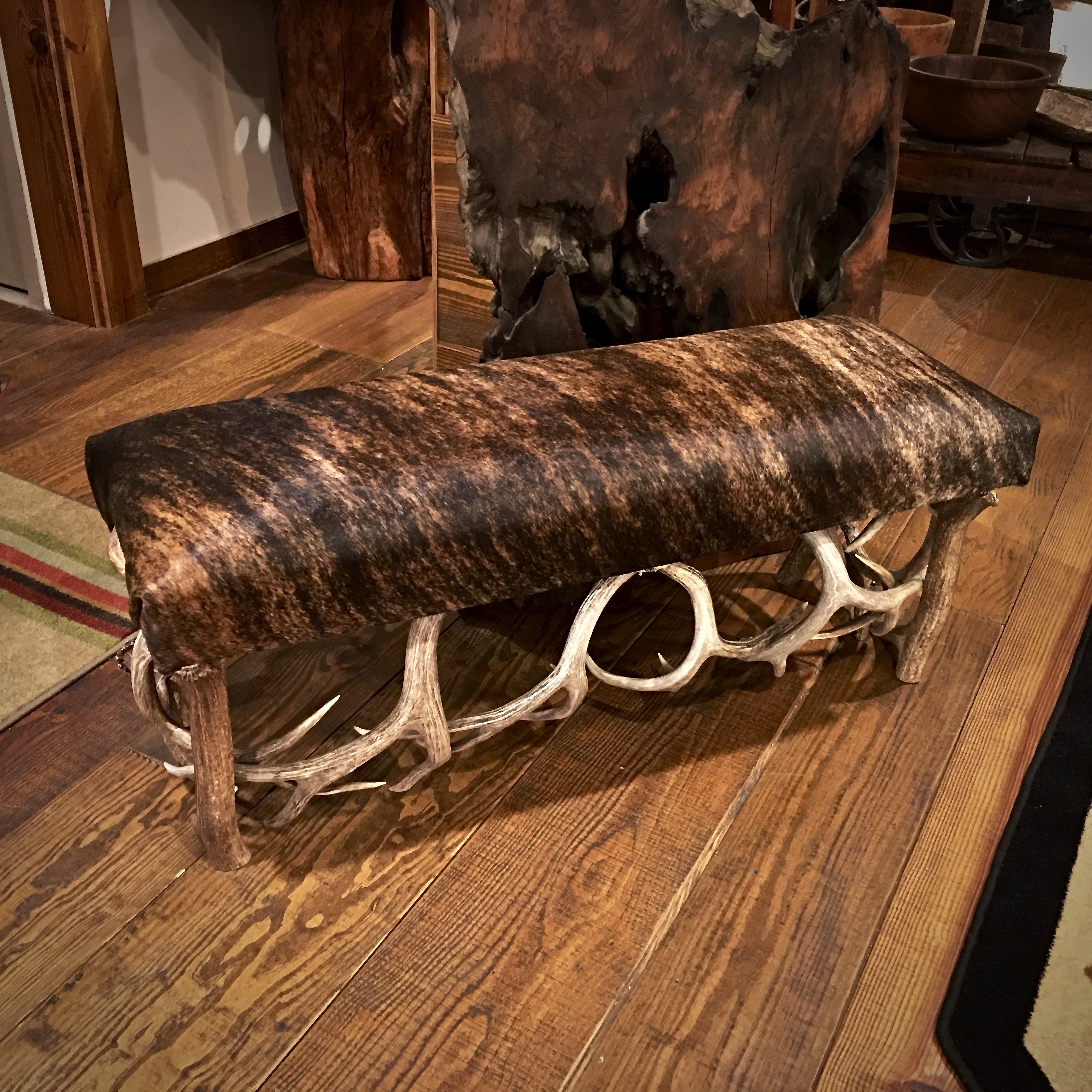 This is a real cowhide and antler bench.