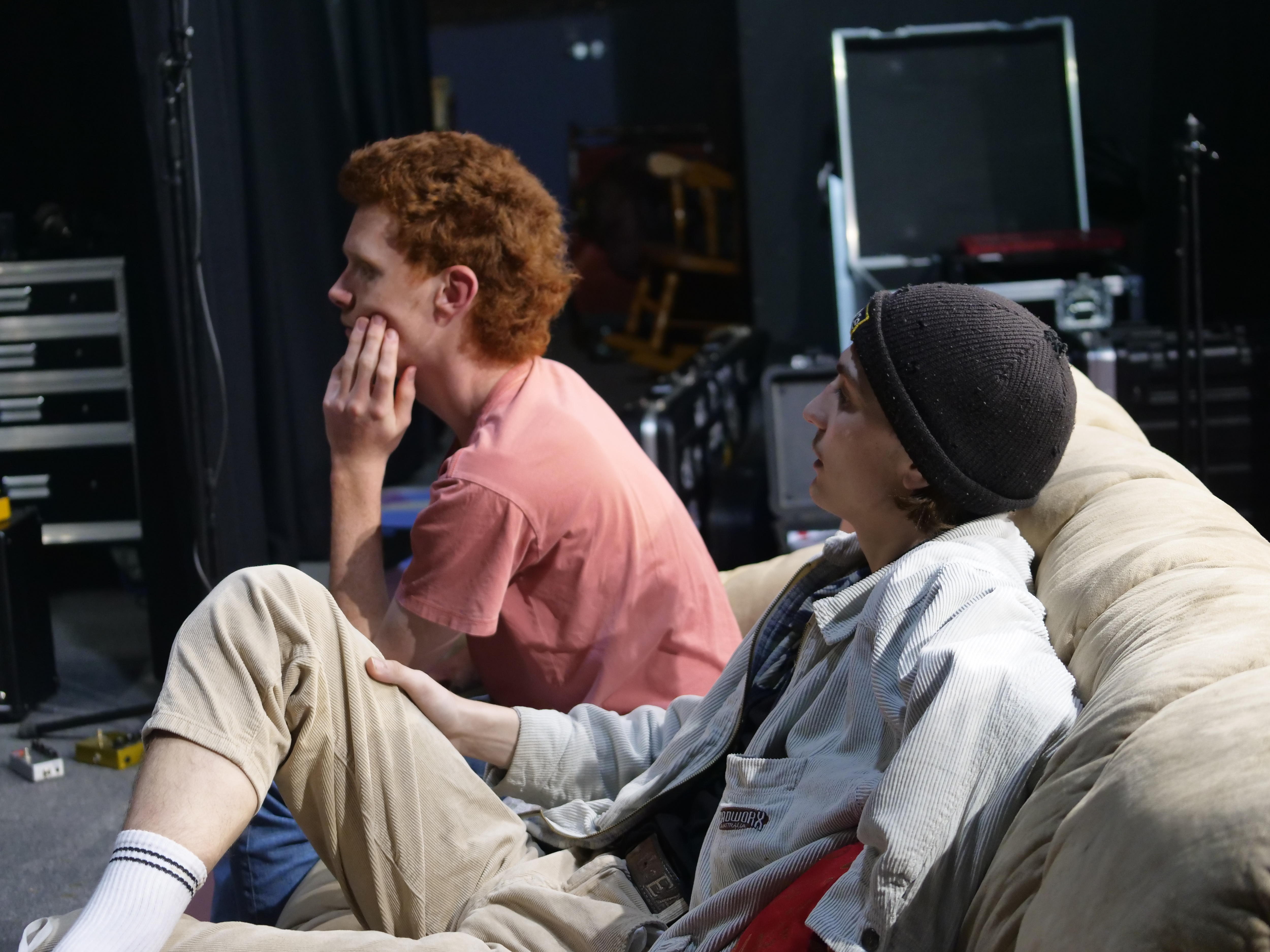 Two young men sitting on a couch.