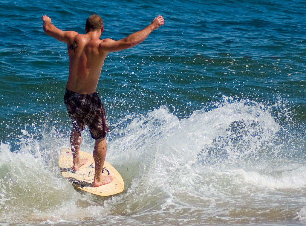 Skim Boarding A beach enthusiast is skimming along the sho… Flickr