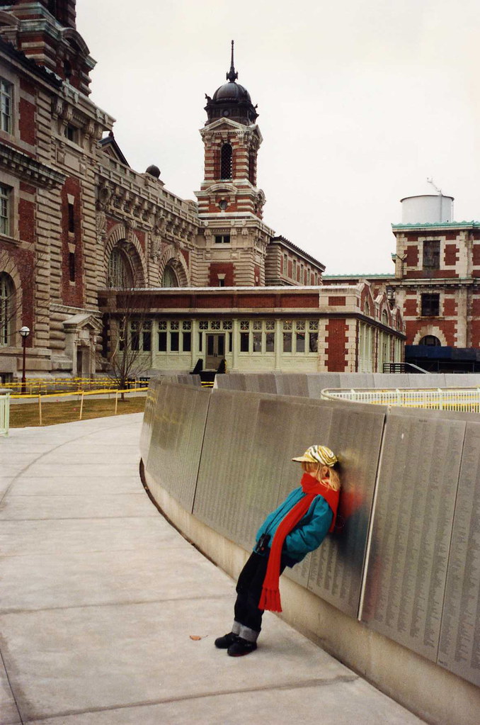 Casey and the wall of names, outside main building at Ellis Island a