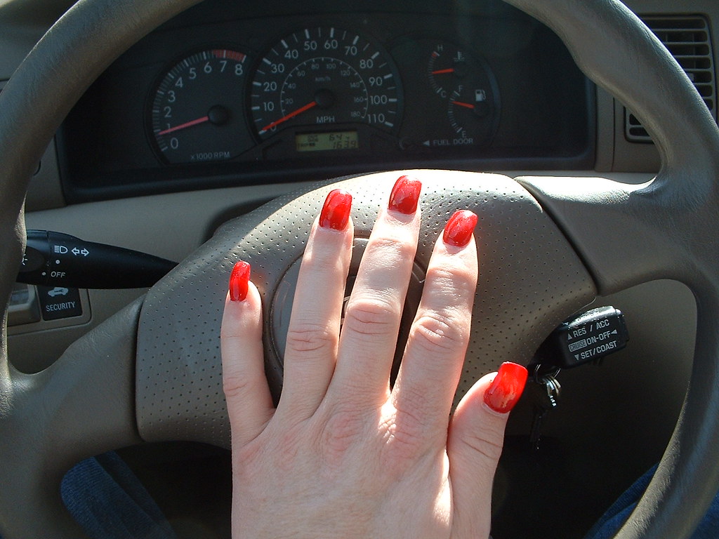 red acrylic nails on steering wheel You can see the sun li… Flickr