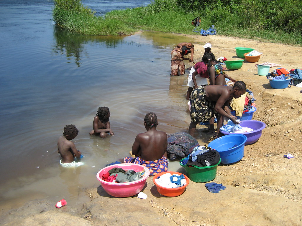 In the river Women washing clothes and children having a b… Flickr