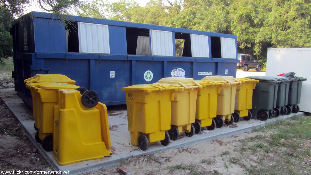 Yellow and green Toters with recycling rolloff dumpster a photo on