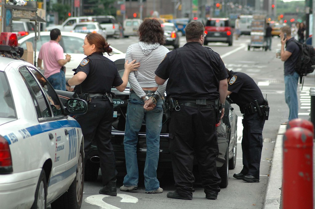 cuffed Suspect is cuffed as officers check out his car. Ethan Flickr