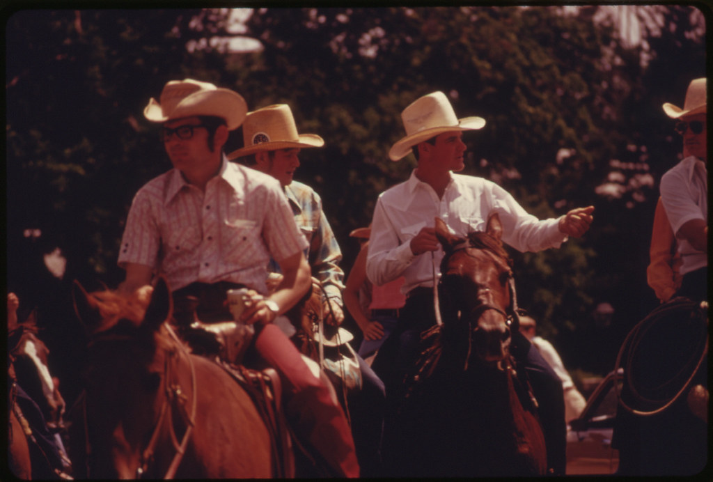 Horse Riders, One with a Can of Beer, Parade Down the Main Street of