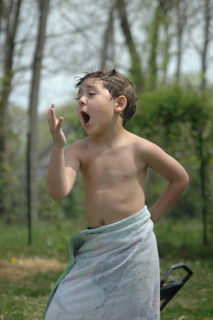 Boy wrapped in towel, singing to hand Ron Ribiat Flickr