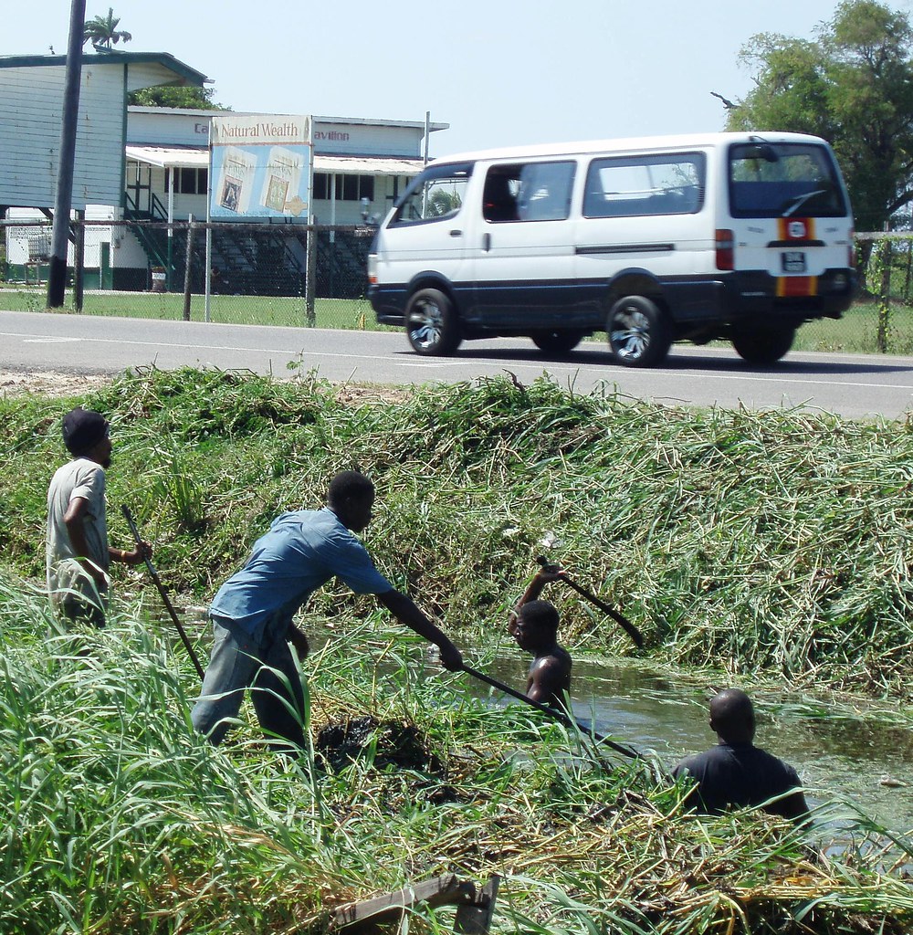 Cleaning the Drains Workers clearing the drains of grass. … Flickr